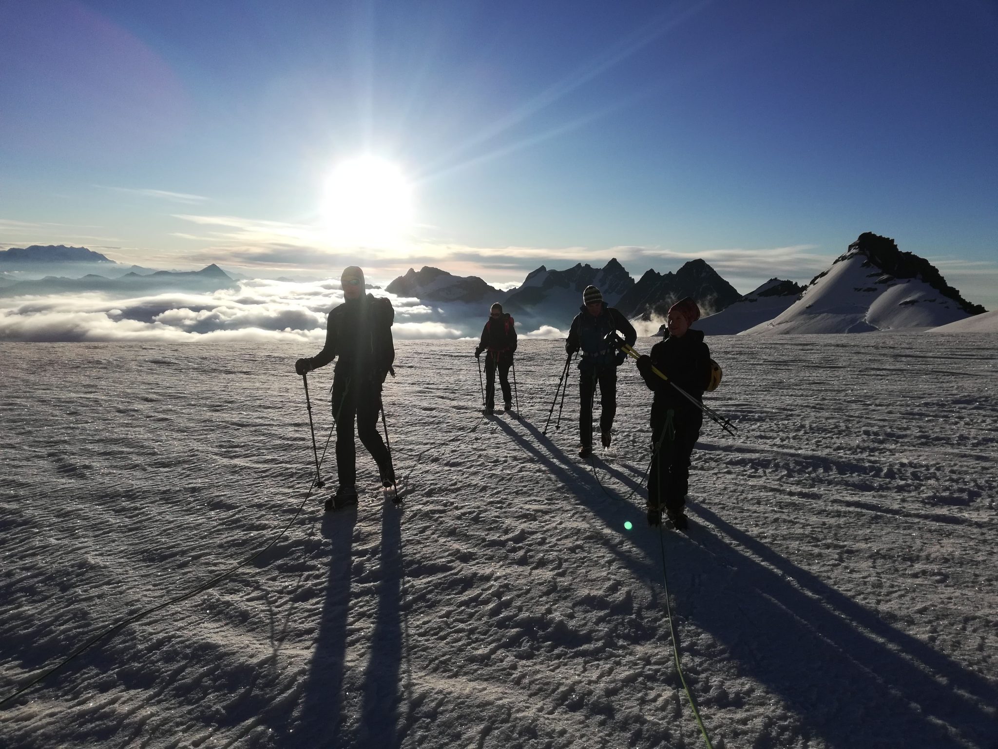 Alba sul ghiacciaio della tribolazione, alpinisti procedono in cordata assieme alla loro Guida Alpina
