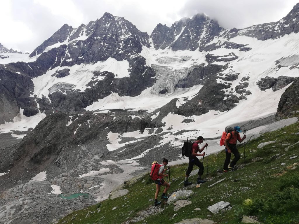 Alpinisti salgono con sullo sfondo la Roccia Viva e la Becca di Gay con i loro maestosi ghiacciai