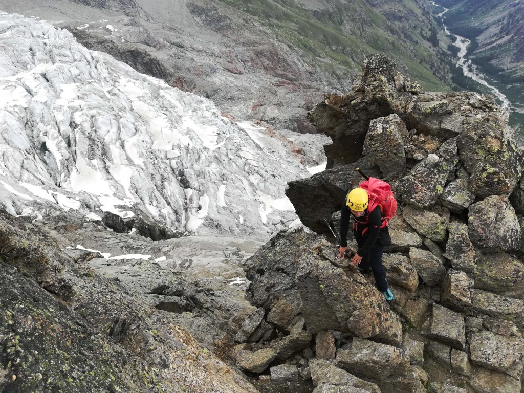 Alpinista lungo la salita al Bivacco Grappein, sullo sfondo il ghiacciaio e il fondo della Valnontey