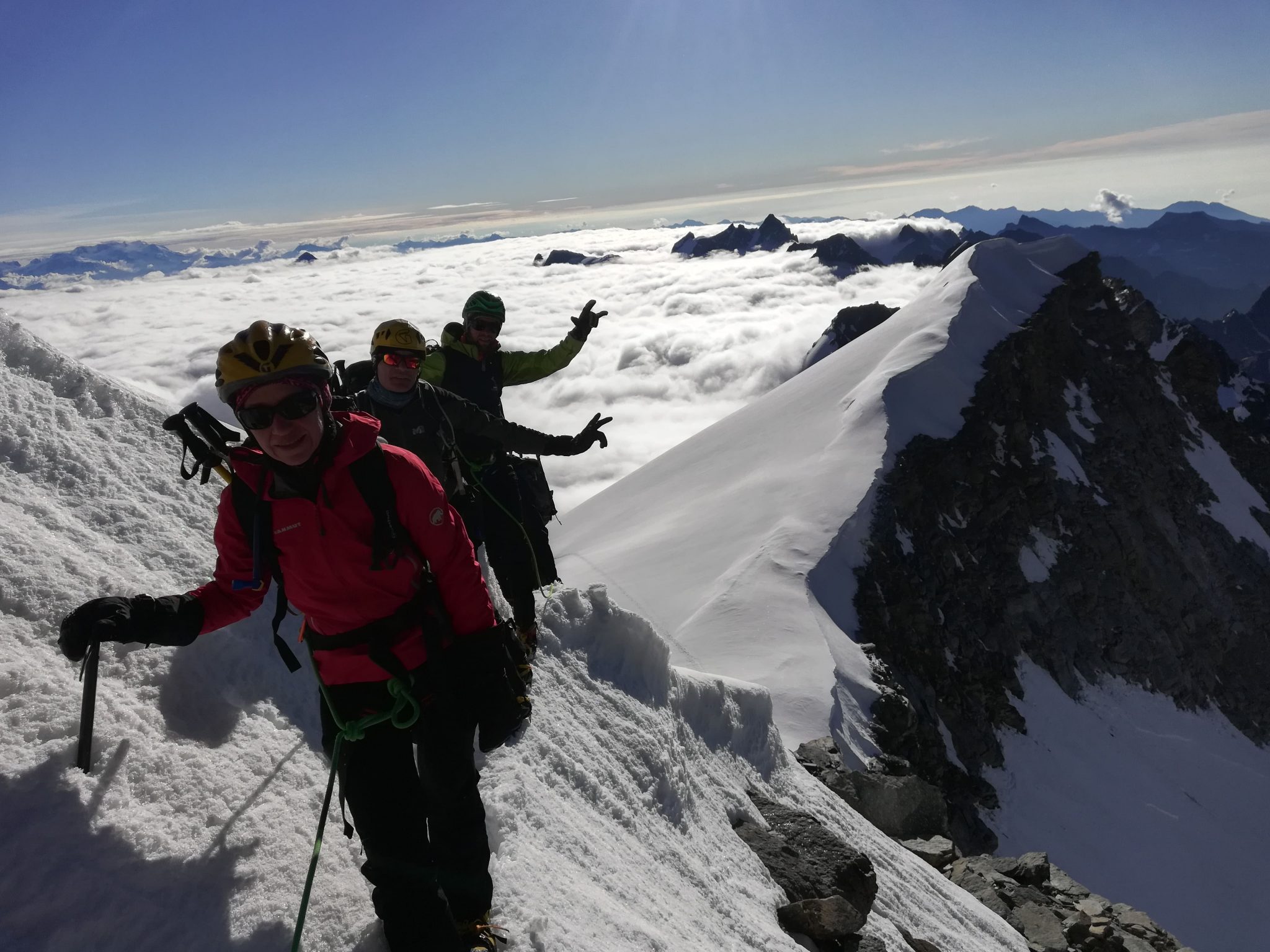 Alpinisti durante l'ascesa verso il Gran paradiso da Cogne assieme alla Guida Alpina nei pressi del colle dell'Ape. Sullo sfondo un mare di nuvole