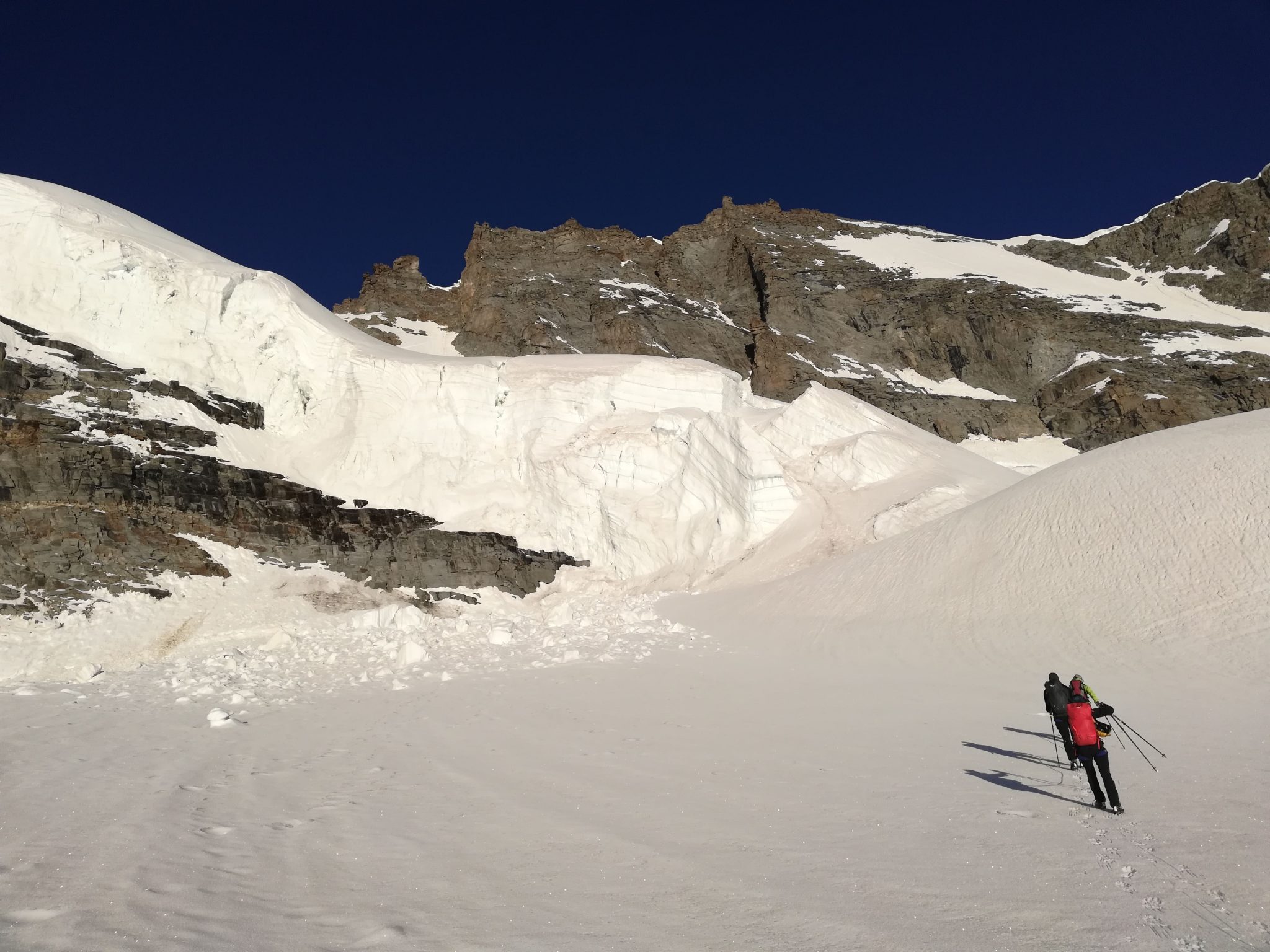 Alpinisti sul Ghiacciaio della Tribolazione durante l'ascesa del Gran Paradiso. Sullo sfondo la vetta del Gran Paradiso