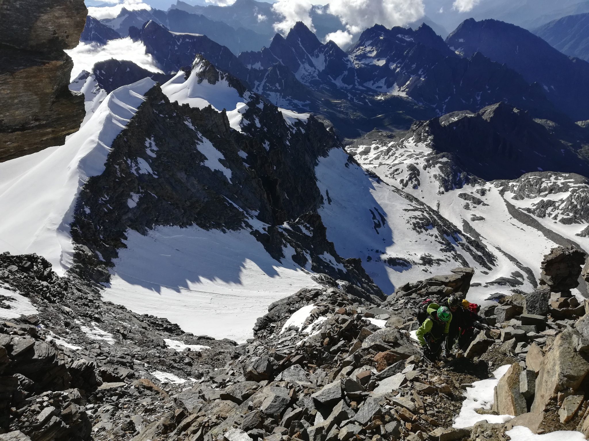 alpinisti risalgono il tratto di terreno misto sopra al Colle dell'Ape. Sullo sfondo al centro il Becco meridionale dellaTribolazione