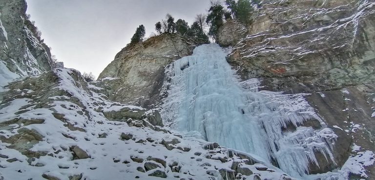 Un'imponente cascata di ghiaccio tra alte pareti rocciose