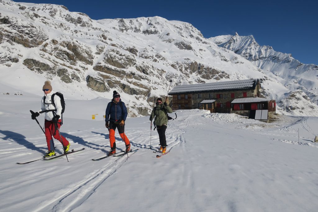 Tre scialpinisti lasciano il rifugio Benevolo di prima mattina, in partenza per la Punta Calabre